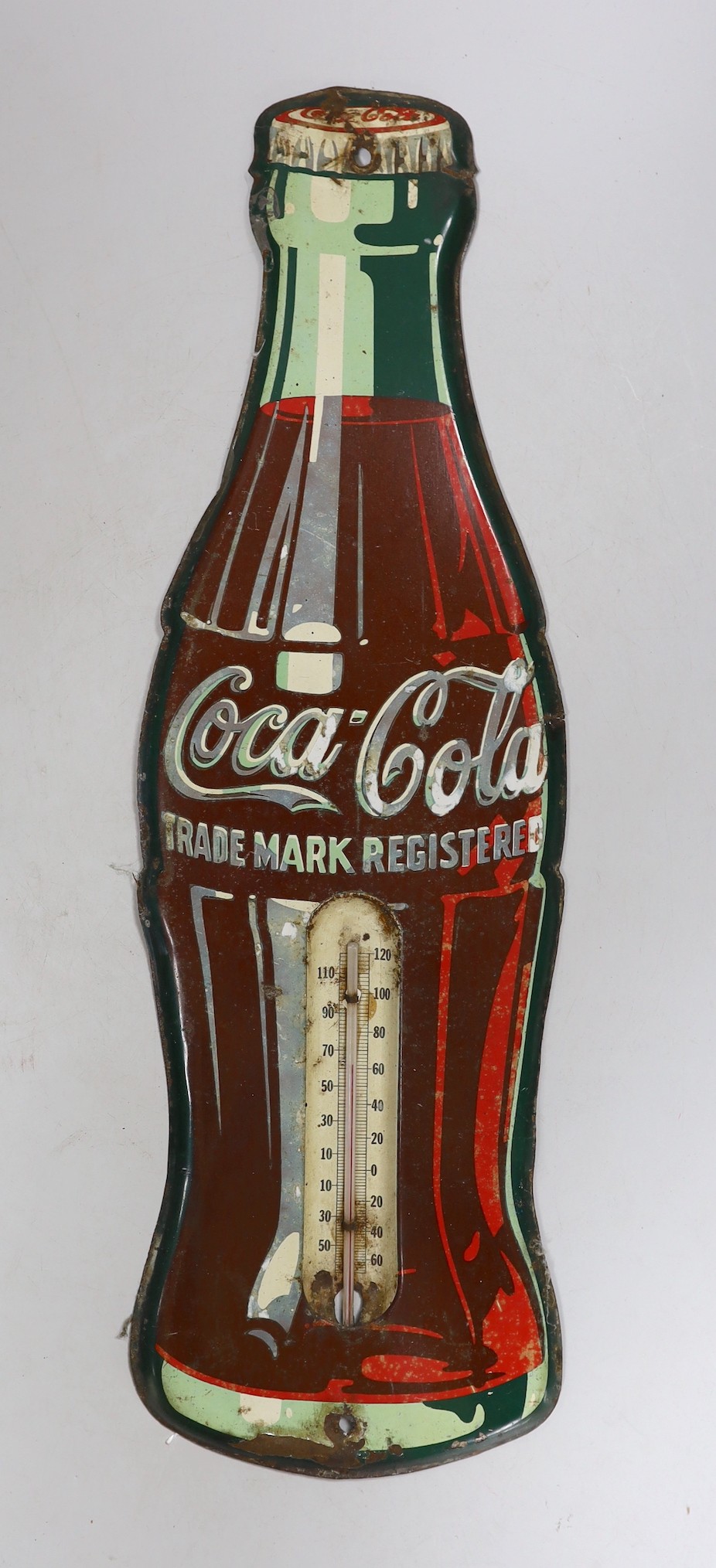 An enamelled Coca-Cola sign in the shape of a bottle, with a thermometer, 43cms high